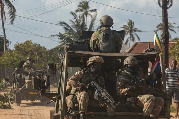 A military convoy of South Africa National Defence Forces rides along a dirt road in the Maringanha district in Pemba, Mozambique.  