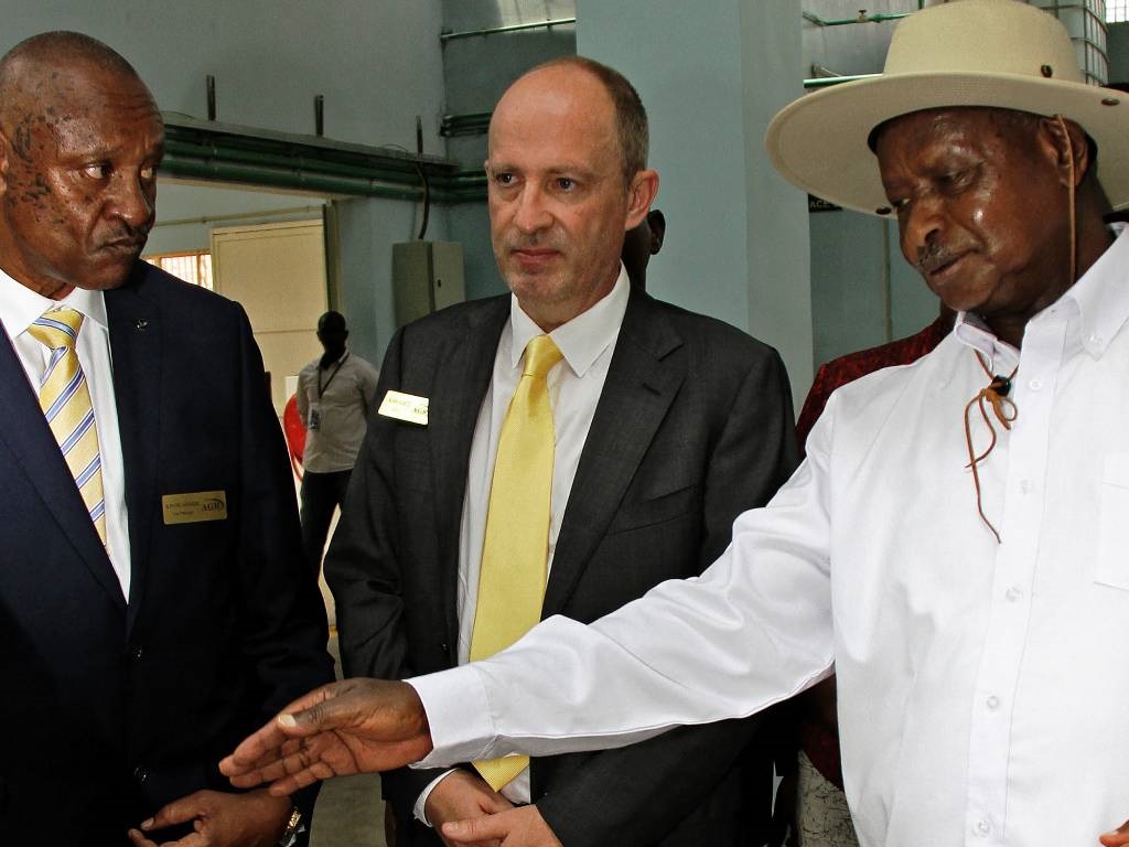 President of Uganda Yoweri Museveni (R) and Alain Goetz, CEO of AGR Limited (C) are shown gold flakes at the African Gold Refinery (AGR ltd) in Entebbe.