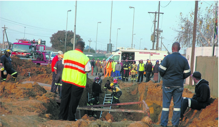 Emergency workers worked around the clock on Monday to retrieve Nathi Mbatha’s body from the trench which collapsed.     Photo by   Phineas Khoza