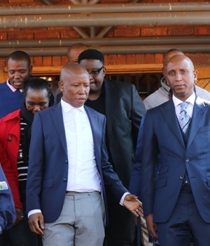 Julius Malema leaves the court after the bail hearing of his lawyer Tumi Mokoena, right. Photo by News24