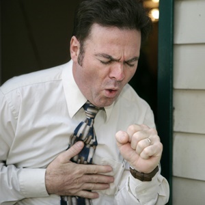 Man holding chest and coughing