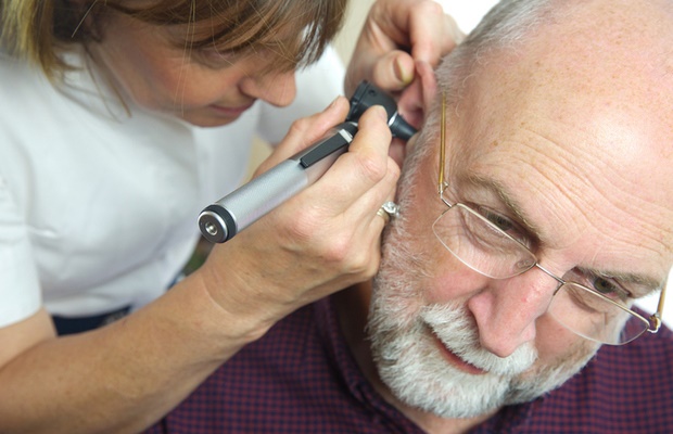 man having ears examined by his doctor 