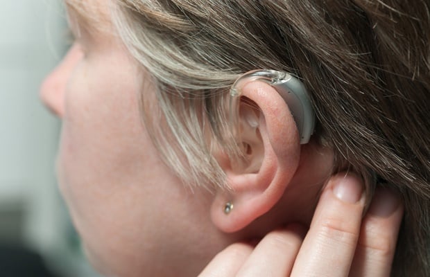 woman wearing her hearing aid 