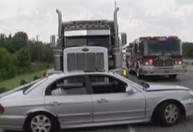 <B>BIG CRASH:</B> A driver found herself facing the grille of a huge 18-wheeler during a bizarre crash along a Texas highway. <I>Image: KHOU News</I>