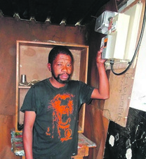 Misheck Swelindawo worries about a shack fire as his meter doesn’t work so he uses candles.   Photo by Vincent Lali