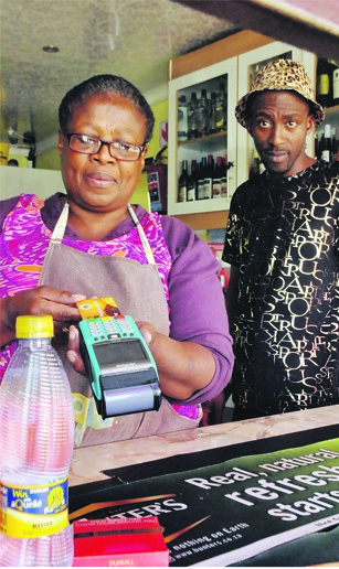 Maggie Mothobi (left) from Diepkloof helps George Partjie with his card purchase. Photo by Thabo Monama