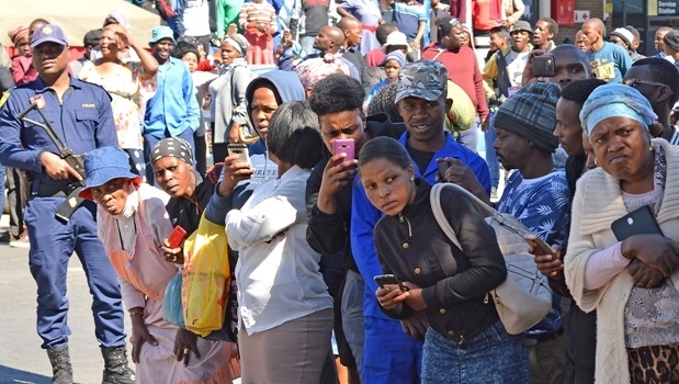Residents crowd the area in the hopes of catching a glimpse of the four men arrested for eating human flesh. Photo by Chelsea Pieterse