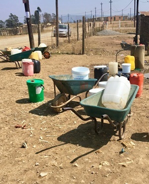 Water containers at the township's only working tap. Photo: GroundUp,