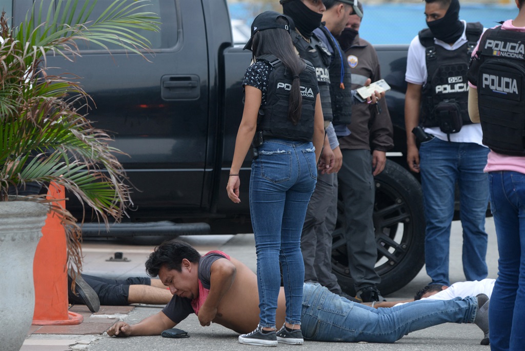Ecuadorean police officers guard the arrested suspects outside Ecuador's TC television channel after unidentified gunmen burst into the state-owned television studio live on air on 9 January 2024, in Guayaquil, Ecuador, a day after Ecuadorean President Daniel Noboa declared a state of emergency following the escape from prison of a dangerous narco boss. Gunshots rang out on live TV in violence-torn Ecuador as armed men carrying rifles and grenades stormed the studio shortly after gangsters vowed a "war" against the president's plans to reclaim control from "narcoterrorists".