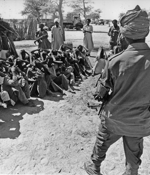 A Chadian guerrilla in the rebel forces of Hissène Habré guards prisoners of war sitting on the ground in Ouaddaï province in eastern Chad in November 1981. Habré later came to power and today stands accused of war crimes and torture in the case agai