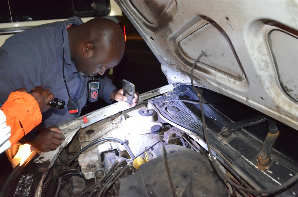  A police officer checking a car engine number dur