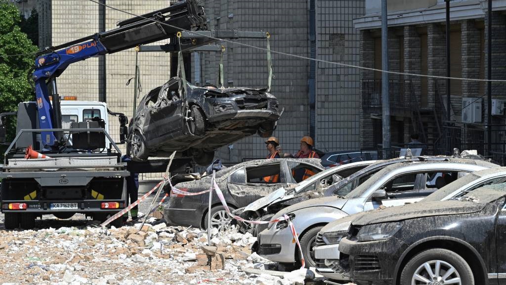 Damaged cars are covered with dust and rubble at t