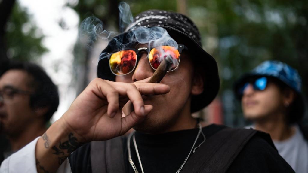 A marijuana user smokes while participating in a march to demand the decriminalisation of cannabis. (Yuri Cortez/AFP)
