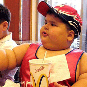 Obese boy snacking at a MC Donald's restaurant 