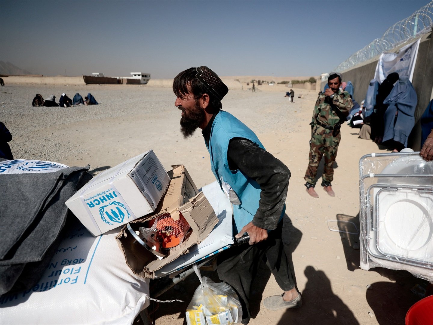 An UNHCR worker pushes a wheelbarrow loaded with aid supplies outside a distribution center in Kabul on Oct. 28, 2021. Zohra Bensemra/Reuters