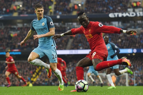 Manchester City's English defender John Stones (L) watches Liverpool's Senegalese midfielder Sadio Mane 