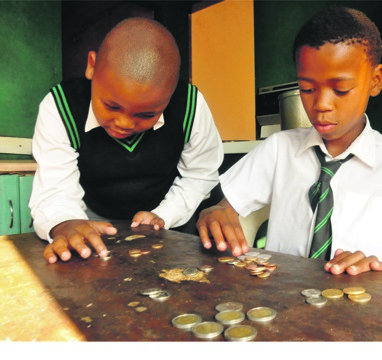 Kutlwano Morore (left) and Tsholofelo Setlhake count coins at home in Diepkloof, Soweto. Photo by Thabo Monama