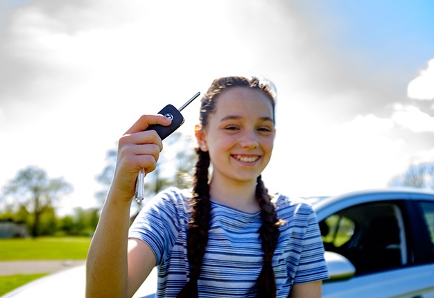 Young driver with car key