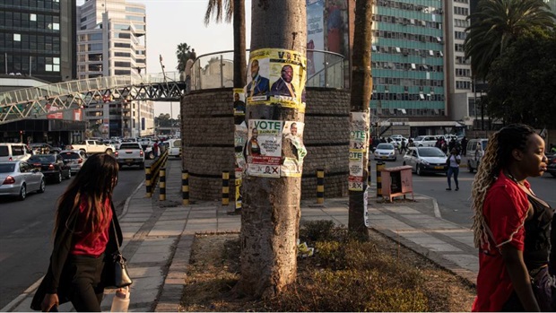<p>Two women walk past Citizens Coalition for Change (CCC) and Zimbabwe African National Union - Patriotic Front (ZANU-PF) election campaign posters in Harare on 22 August 2023. </p><p><em>(Photo by John Wessels/AFP)</em></p>