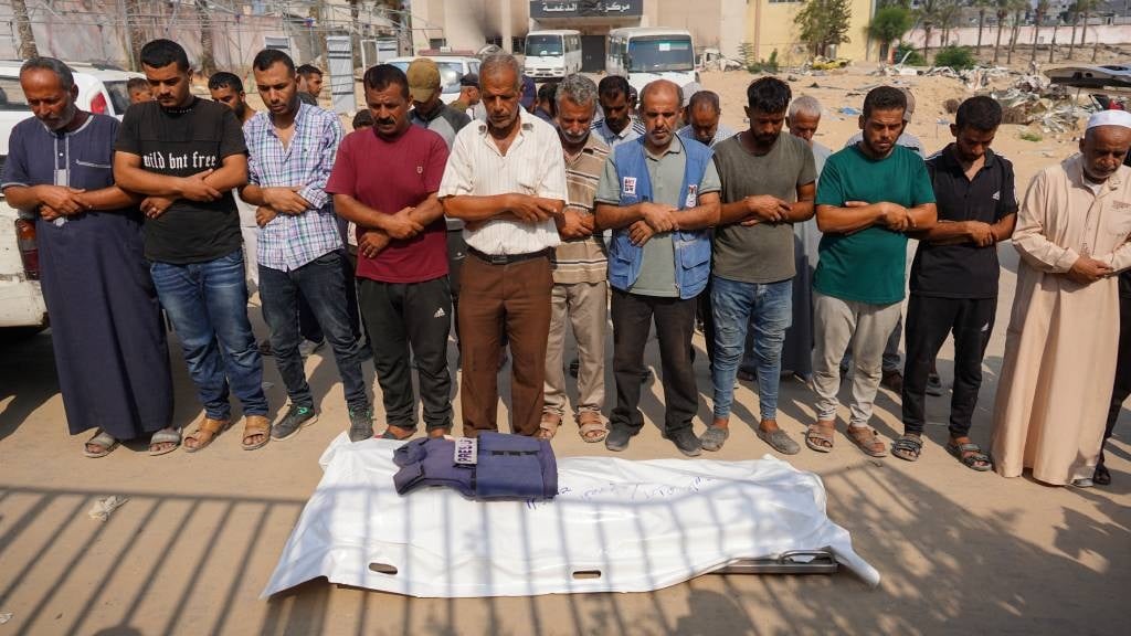 Relatives and friends pray over the body of photojournalist Ibrahim Muharab, who was killed as he was covering the advance of Israeli forces north of Khan Yunis. (Bashar Taleb/AFP)