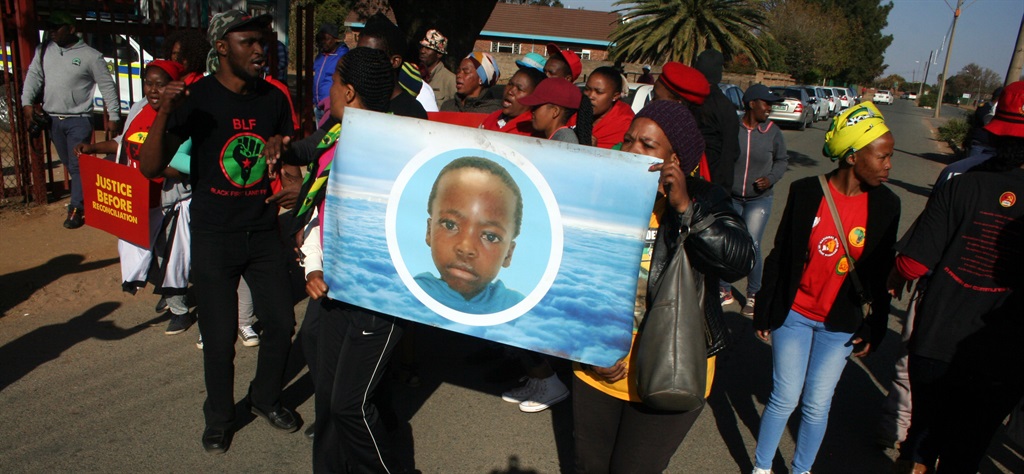 Protesters outside the court in Coligny, North West, where Phillip Schutte and Pieter Doorewaard appeared briefly on charges of Matlhomola Mosweu’s death. The protesters had a poster with a picture of Mosweu printed on it. Picture: Susan Cilliers