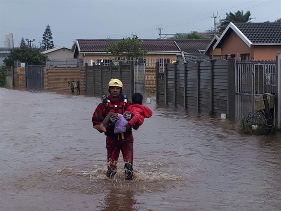 NSRI Durban crew member Julian Singh carrying a child to safety from an entrapment in a home in Montclair.