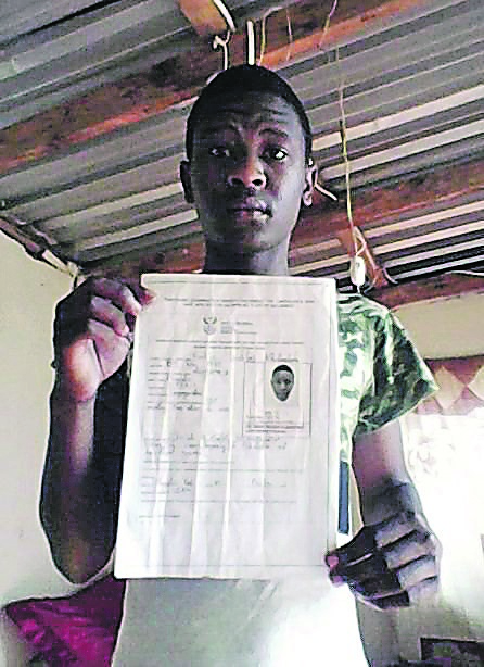 Lindani Radebe holds up the document that enabled him to write his matric exam.