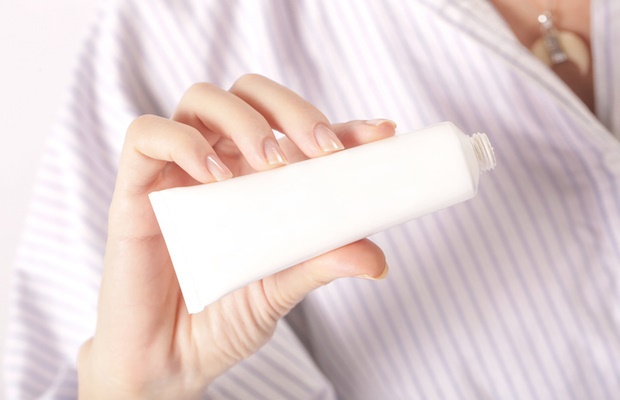 Woman holding tube of lotion 