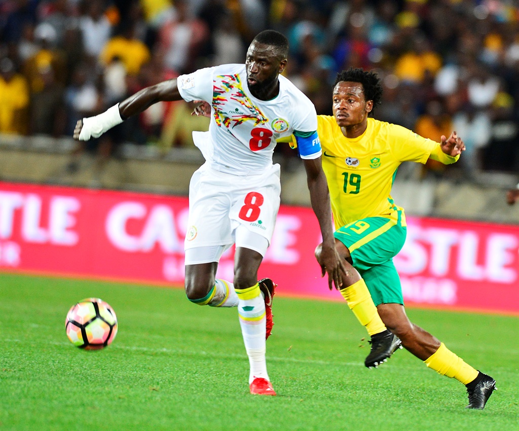 Percy Tau challenged by Senegal midfielder 