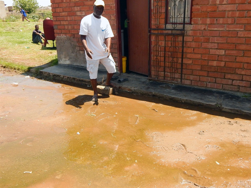 Fungai Tafirenyika shows off the flowing water at the front of his house. Photo by Desmond Boshego.Photo by 