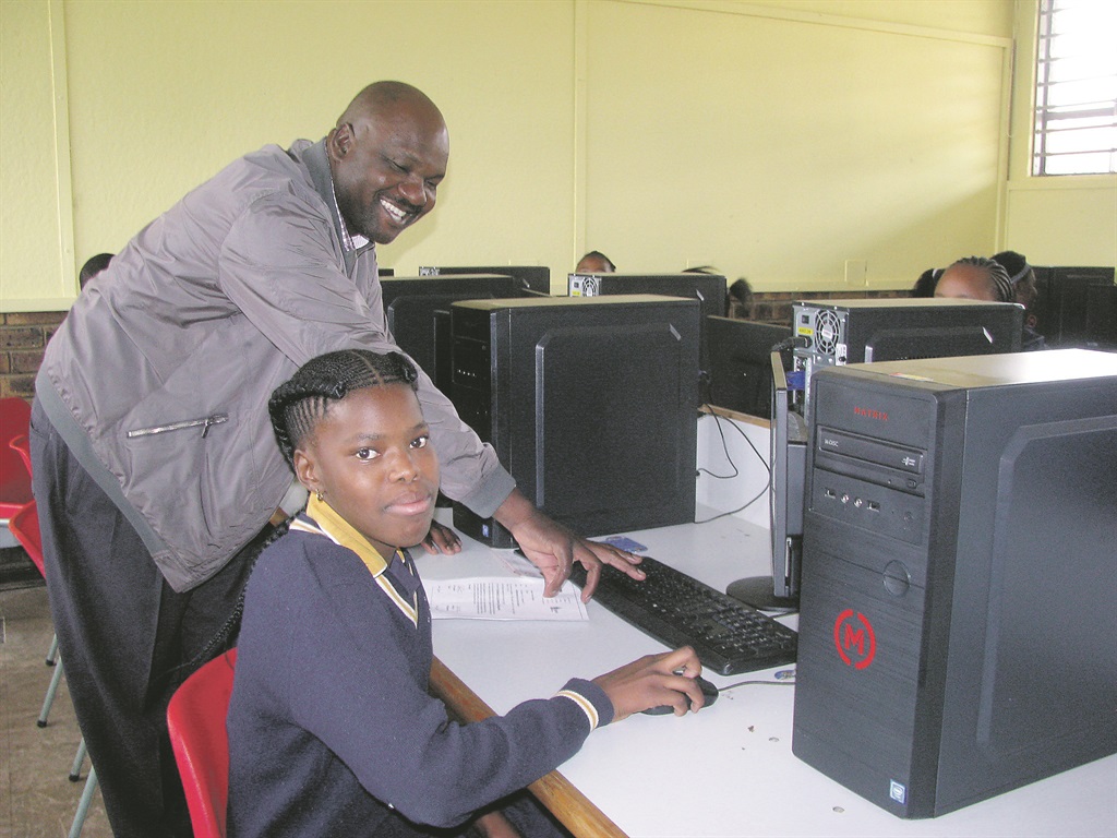 Principal Solani Ngobeni, with Ritshidisitswe Mole, at a new computer. Photo by Kopano Monaheng