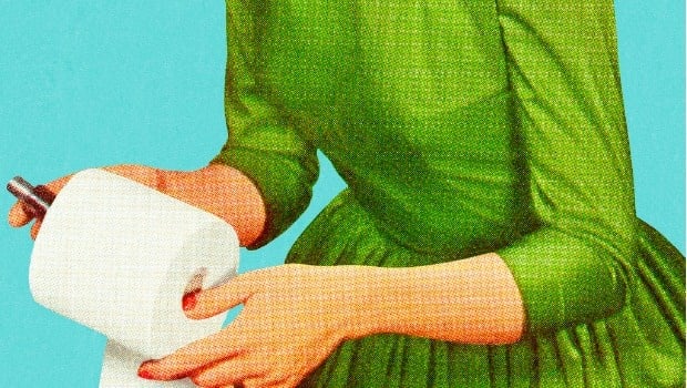 A woman stocks up the bathroom with toilet paper