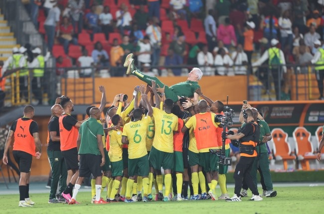 The South African players hoist up their coach, Hugo Broos, as they celebrate winning the penalty shoot-out in the Africa Cup of Nations third place match against DR Congo at Felix Houphouet-Boigny Stadium in Abidjan, Ivory Coast, on Saturday. (Photo by MB Media/Getty Images)