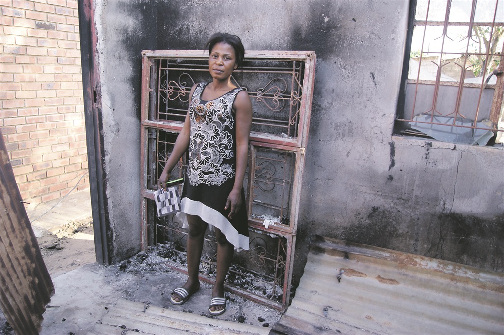 Zanele Ngwenya shows the burnt house. Photo by Elizabeth Langa Photo by 