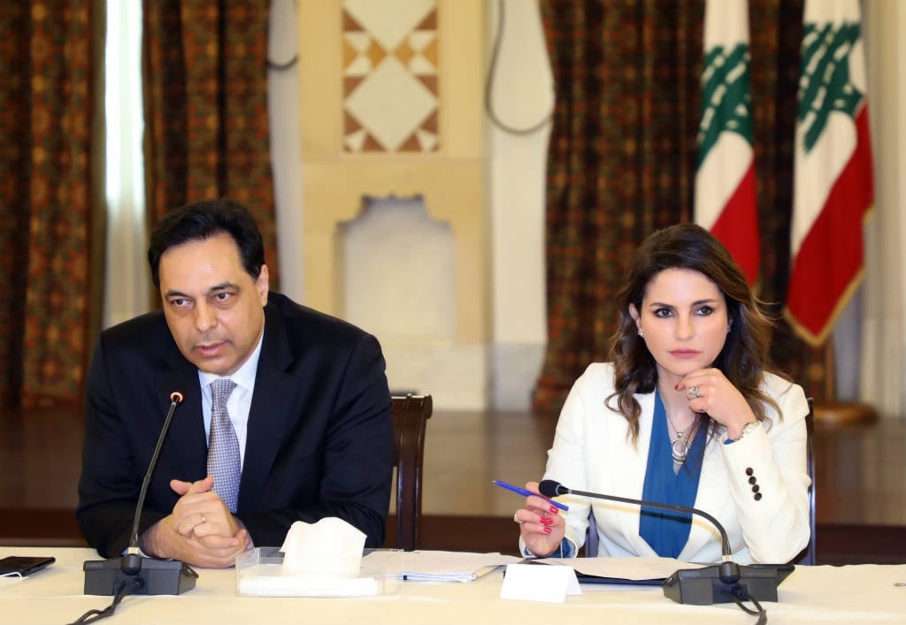 A handout picture shows Lebanon's Prime Minister Hassan Diab (L) and Minister of Information Manal Abdel Samad during an official meeting at the Grand Serail government headquarters in the capital Beirut, on April 24, 2020.