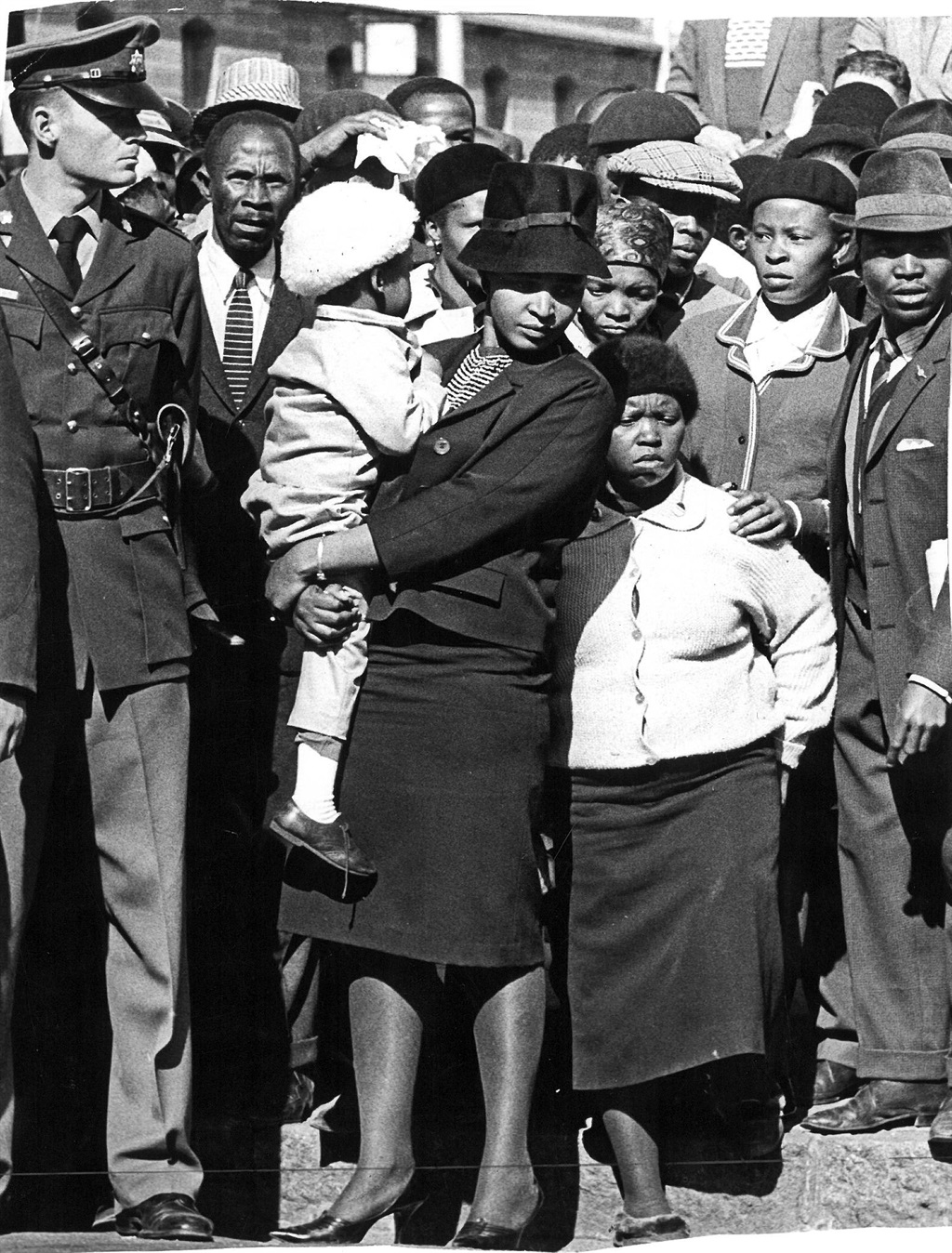 Winnie outside the Palace of Justice in Pretoria during the Rivonia Trial, in which her husband stood accused of treason and which led to him being convicted to life in prison on Robben Island. She is holding a small child, however, the caption for this picture from the Media24 archives does not say which child she is holding. Presumably it is her youngest daughter, Zindzi, who was three years old when the trial started in October 1963