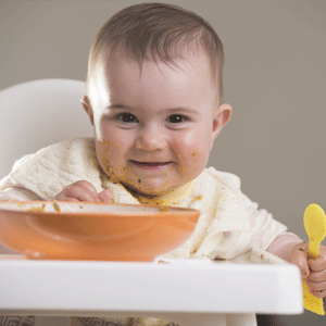 Baby girl with porridge bowl