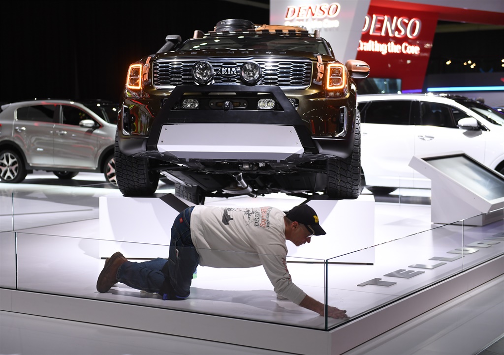 A worker cleans around a KIA truck at the Cobo Center in Detroit Michigan January 13, 2019 as preparations are underway one day before the start of the North American International Auto Show. 