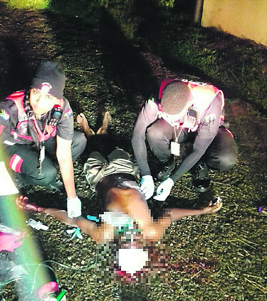 Paramedics give Mike Mpachika first aid after he was shot by unknown suspects. 