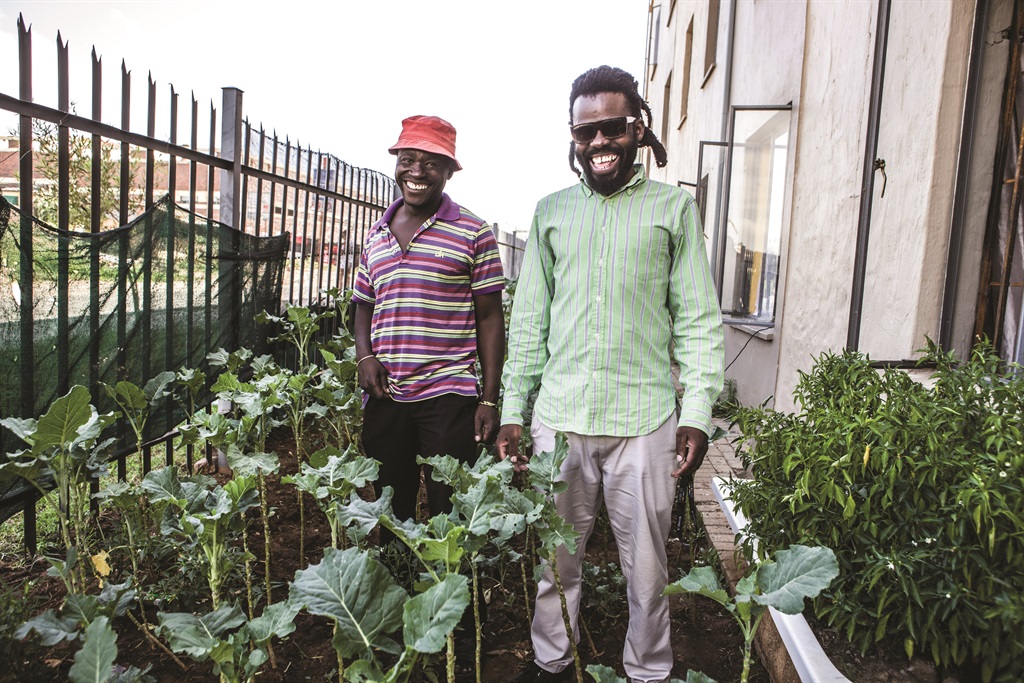 How does your garden grow: The author and his brother show off their vegetable garden, they are making the most of their home away from home. Picture: Mark Lewis.