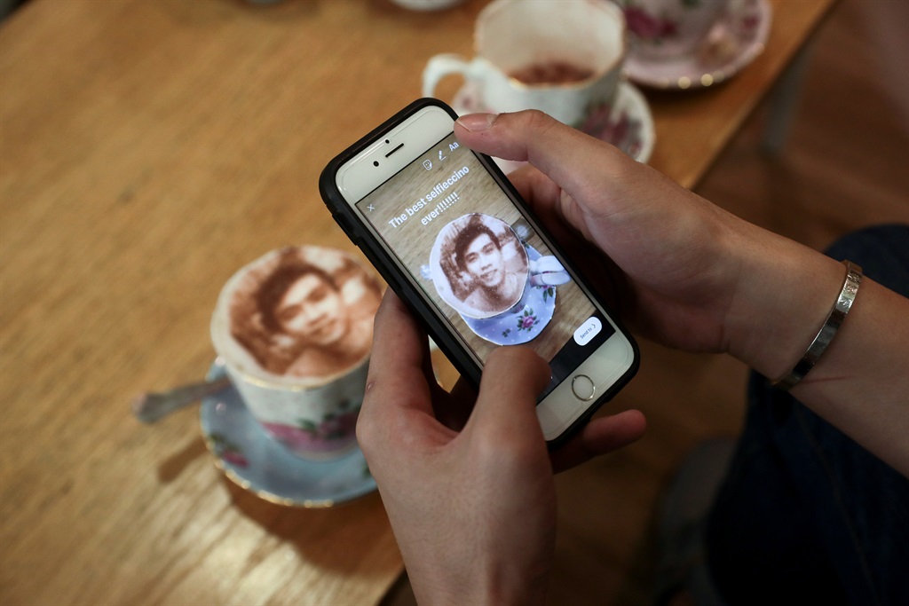 A customer loads a photograph of his 'Selfieccino coffee' on social media at the Tea Terrace in London, Britain. Picture: Simon Dawson/Reuters 