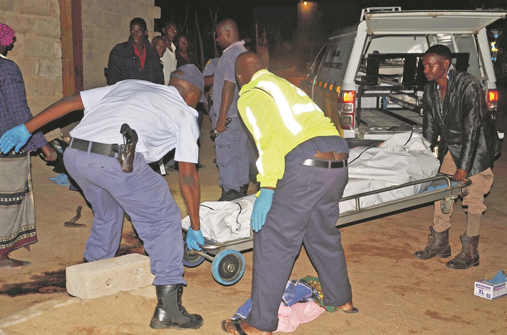 Forensic cops and pathologists lift Maria Ndlovu’s body into the hearse. Photo by Oris Mnisi