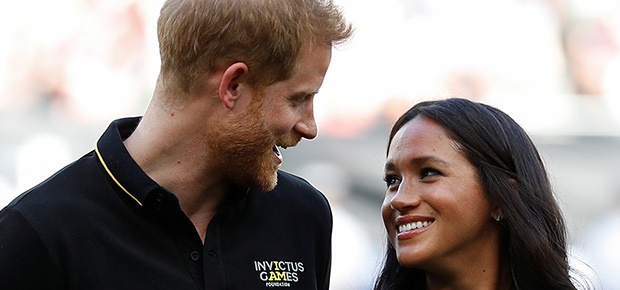 Prince Harry, Duke of Sussex and Meghan, Duchess of Sussex accompany Invictus Games competitors on the field for the ceremonial first pitch. (Getty Images)