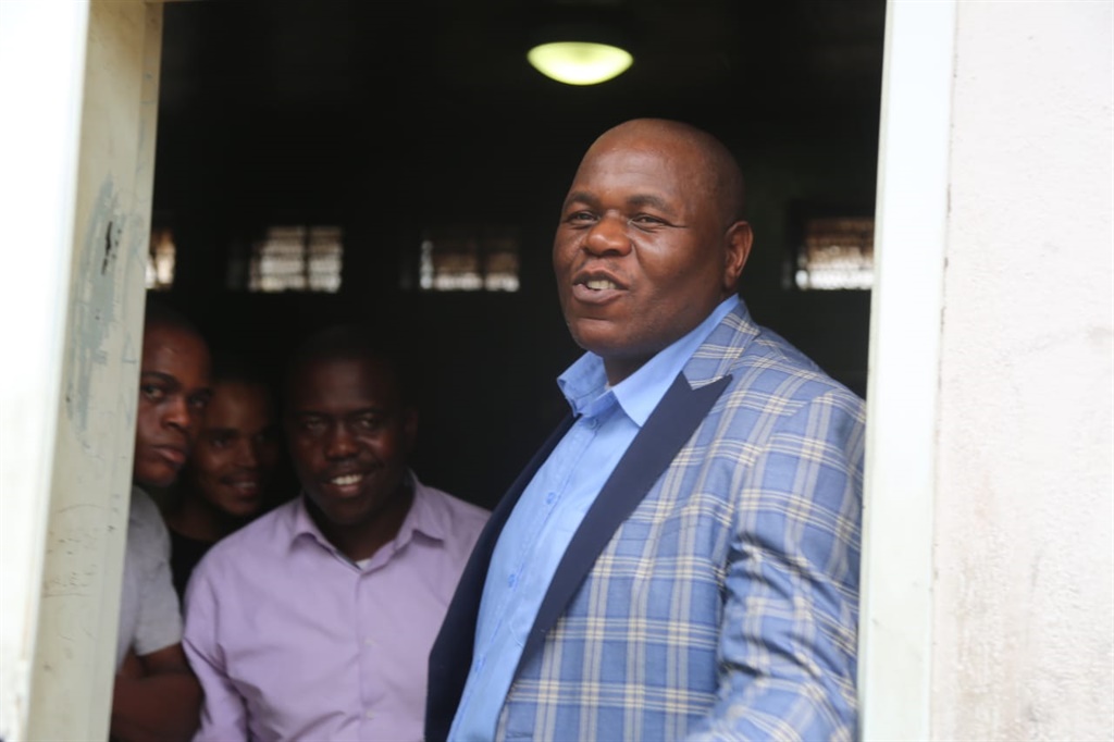 Pastor James Thubakgale smiling  when he was being taken into police cells after his hearing. Photo by Joshua Sebola 