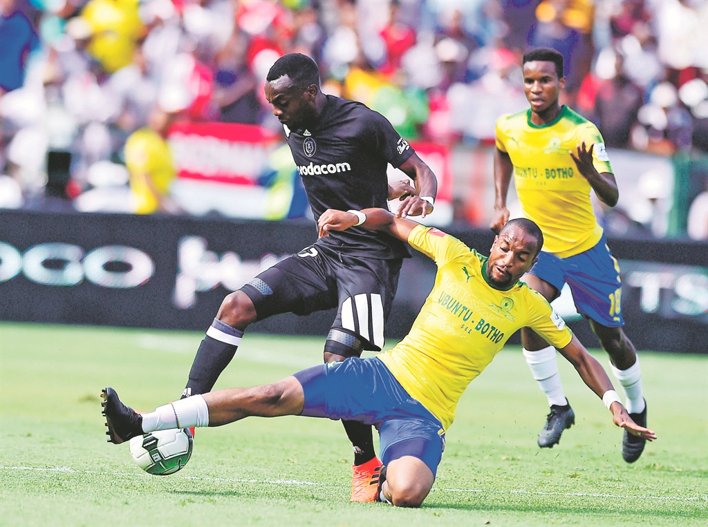 Tussle: Tiyani Mabunda of Mamelodi Sundowns slide tackles Justin Shonga of Orlando Pirates in yesterday’s Absa Premiership match at Loftus Stadium. Picture: Themba Makofane