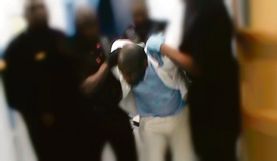 A still from secret footage taken from inside Mangaung Prison of an inmate being restrained and led to receive an injection 