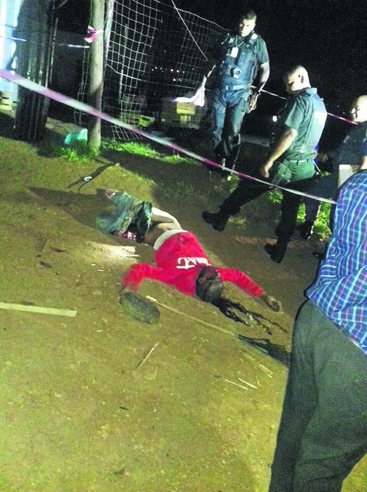 The suspect lying in a pool of blood after being stoned to death by angry residents. 