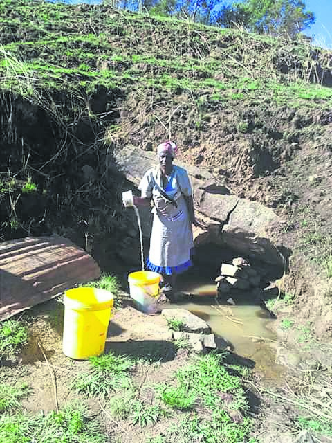 A woman fetches water from a dirty stream not far from uThukela water supply scheme. Photo by Willem Phungula