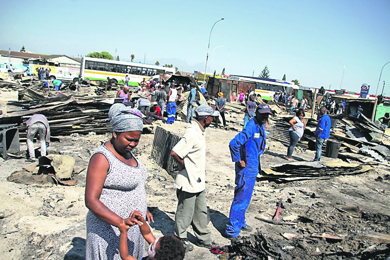 Residents have already started to rebuild their shacks, which were destroyed by a fire.         Photo by Lindile Mbontsi