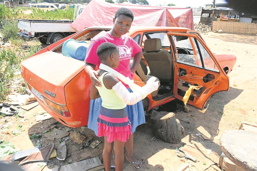Molebogeng Moji and her injured daughter Zama next to the car where she was hurt.       Photo by Muntu Nkosi
